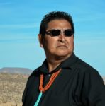 Portrait of Clark Tenakhongva in front of daytime desert landscape